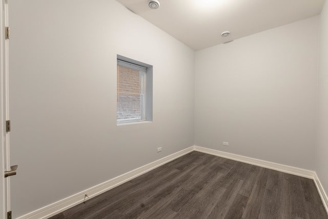 unfurnished room with dark wood-type flooring