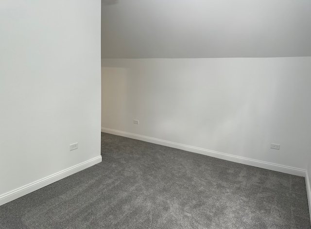 interior space with dark carpet and lofted ceiling