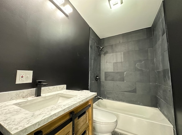 full bathroom featuring tiled shower / bath, vanity, and toilet