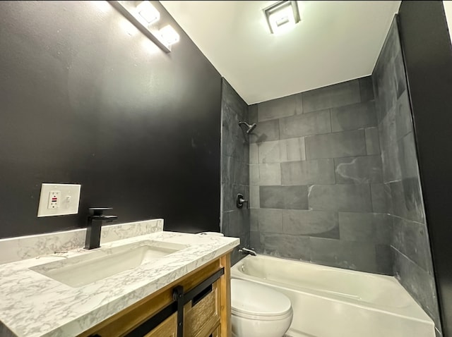 full bathroom featuring tiled shower / bath, vanity, and toilet