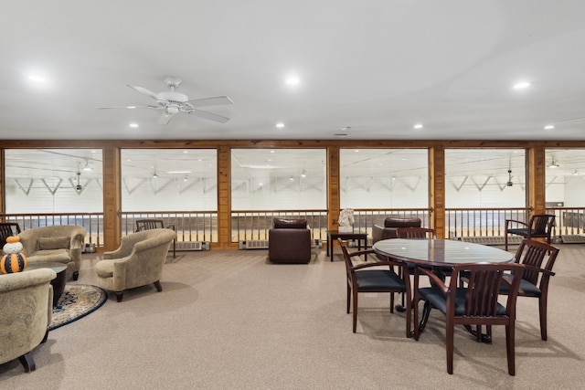 dining area with ceiling fan and light colored carpet