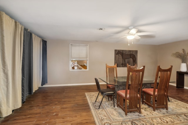 dining space featuring ceiling fan and dark wood-type flooring