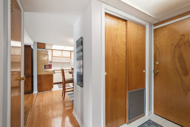 corridor featuring light hardwood / wood-style floors and sink