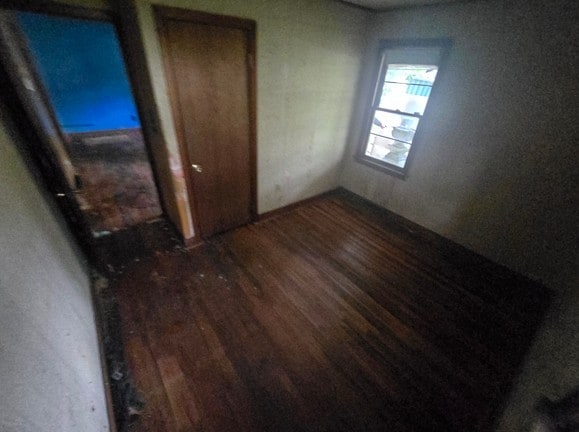 unfurnished bedroom with a closet and dark hardwood / wood-style flooring