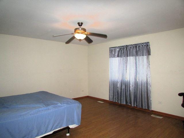 bedroom with baseboards, a ceiling fan, and wood finished floors