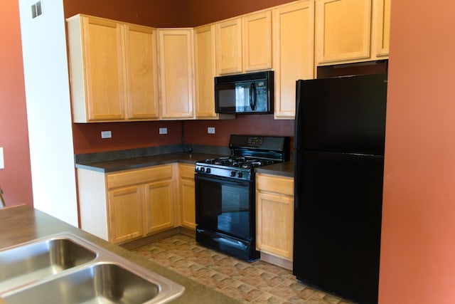 kitchen featuring black appliances and light brown cabinets