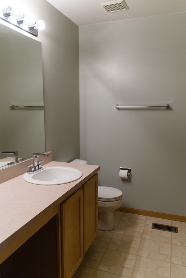 bathroom featuring tile patterned flooring, vanity, and toilet