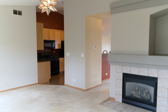 unfurnished living room with light carpet, a fireplace, vaulted ceiling, and a notable chandelier