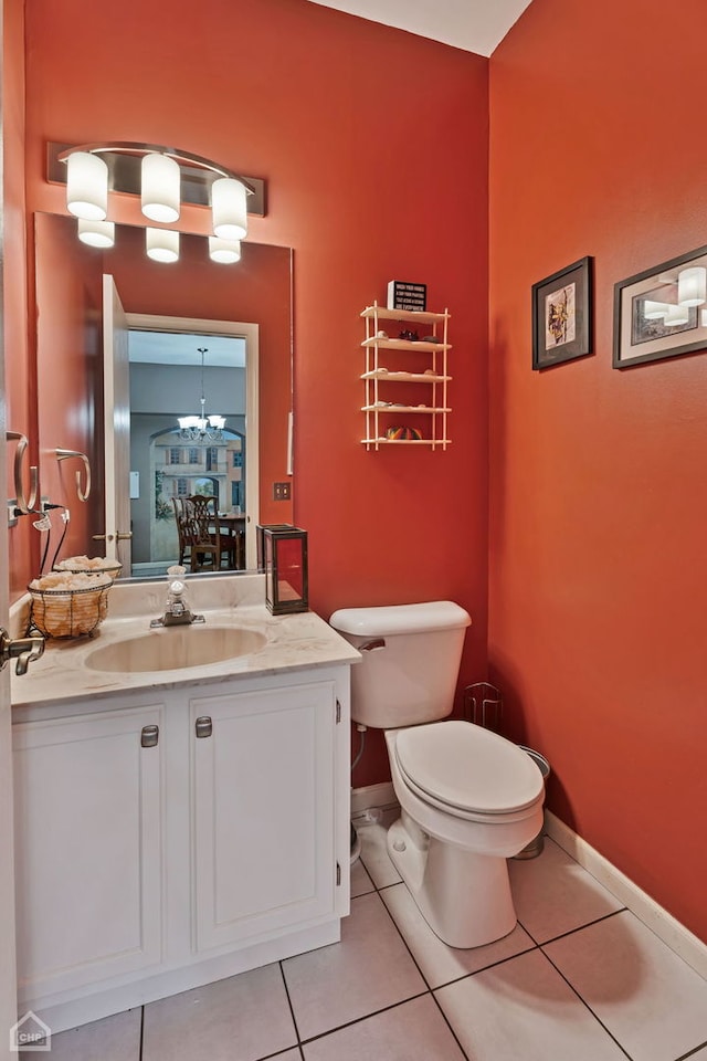 bathroom with vanity, a notable chandelier, toilet, and tile patterned flooring