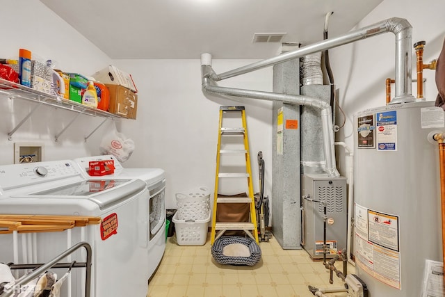 washroom with water heater, heating unit, and washing machine and dryer