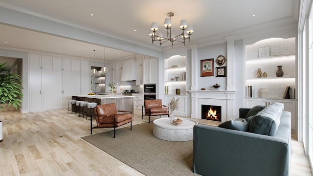 living room featuring light hardwood / wood-style floors, an inviting chandelier, ornamental molding, and sink