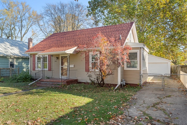 view of front of house with an outbuilding, a garage, and a front lawn