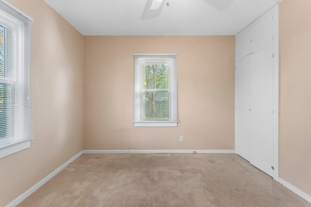 unfurnished room with light carpet and ceiling fan