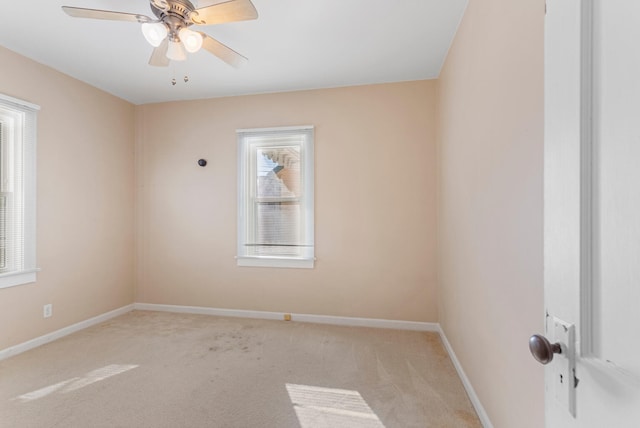 spare room with a wealth of natural light, light carpet, and ceiling fan