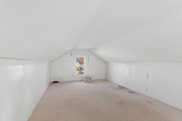 additional living space featuring lofted ceiling and light carpet