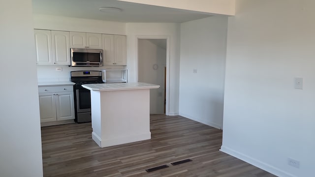 kitchen featuring dark hardwood / wood-style floors, white cabinets, appliances with stainless steel finishes, and tile counters