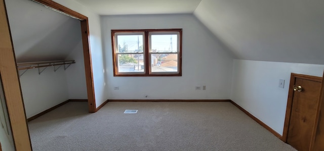 bonus room featuring light colored carpet and vaulted ceiling