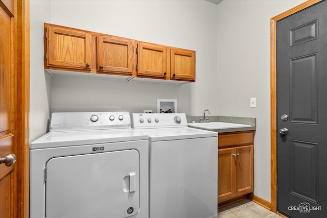 washroom featuring washing machine and dryer, sink, light tile patterned floors, and cabinets