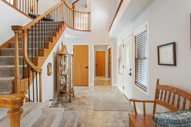 foyer with a towering ceiling and hardwood / wood-style floors