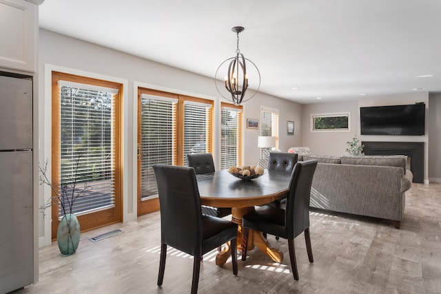 dining room with light hardwood / wood-style floors and a chandelier