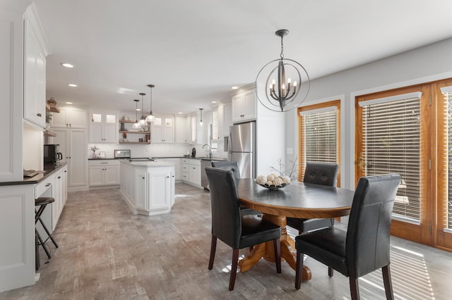 dining room featuring sink, light hardwood / wood-style flooring, and a chandelier