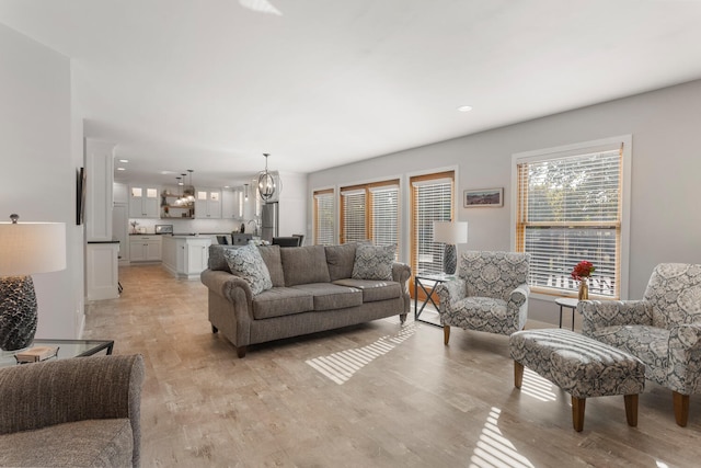 living room with an inviting chandelier and light wood-type flooring