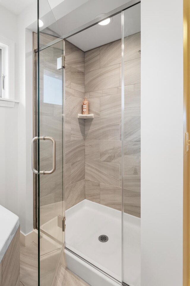 bathroom featuring a shower with door