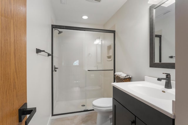 bathroom featuring toilet, tile patterned flooring, vanity, and a shower with shower door