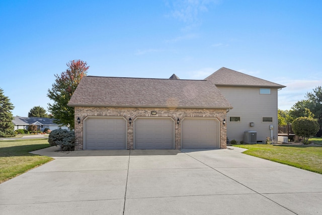 view of front of house with a front lawn, central AC unit, and a garage