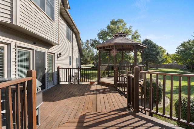 wooden terrace featuring a gazebo and a lawn