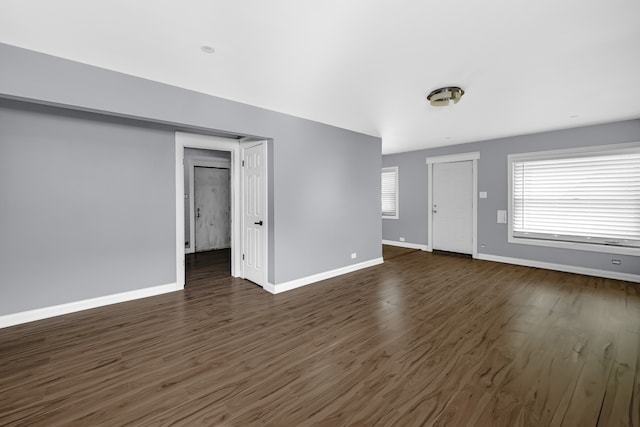 unfurnished living room featuring dark wood-type flooring