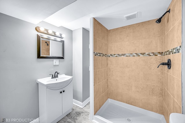 bathroom with vanity, a tile shower, and toilet