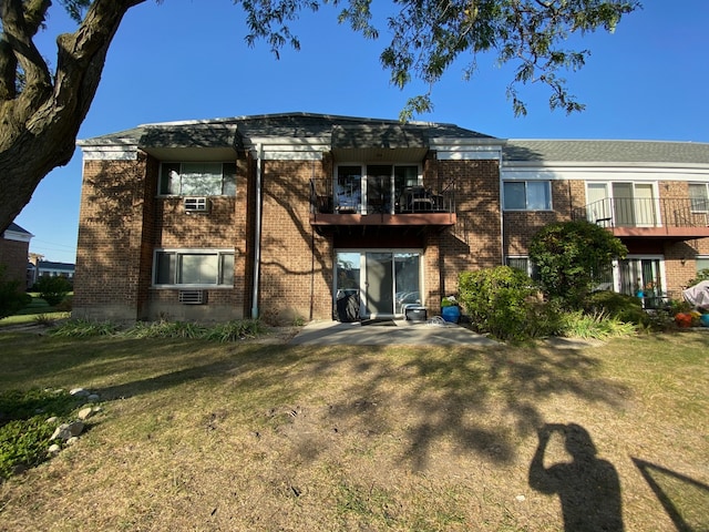 rear view of property with a yard and a balcony