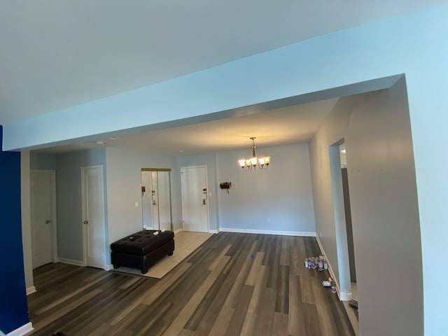 interior space featuring an inviting chandelier and dark wood-type flooring