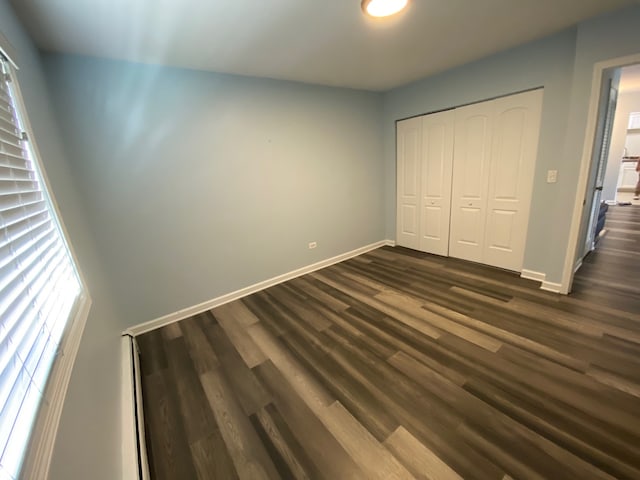 unfurnished bedroom featuring a closet and dark hardwood / wood-style floors