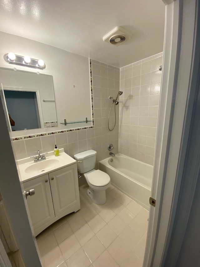 full bathroom featuring vanity, tiled shower / bath, tasteful backsplash, tile patterned floors, and toilet