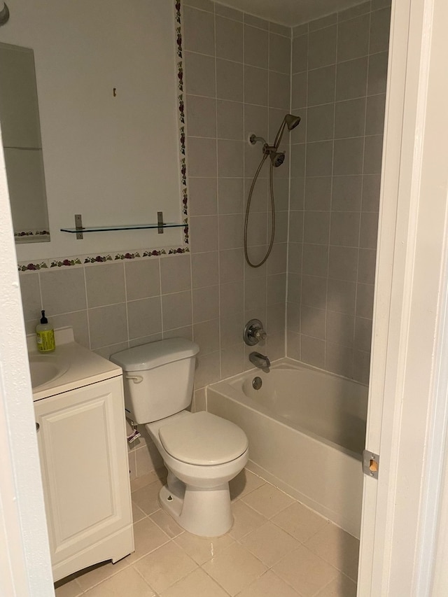 full bathroom featuring vanity, tile walls, tiled shower / bath combo, tile patterned flooring, and toilet