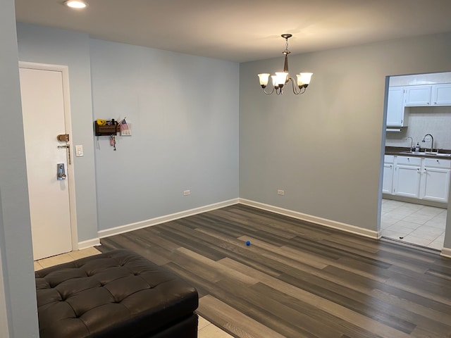 dining space with a notable chandelier, sink, and light hardwood / wood-style floors