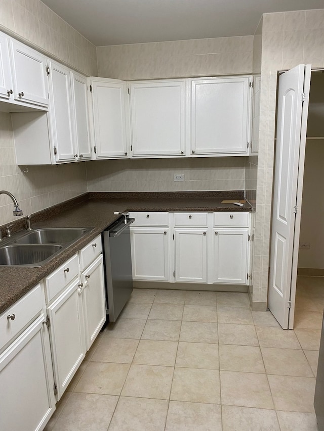 kitchen featuring light tile patterned floors, white cabinetry, sink, and stainless steel dishwasher