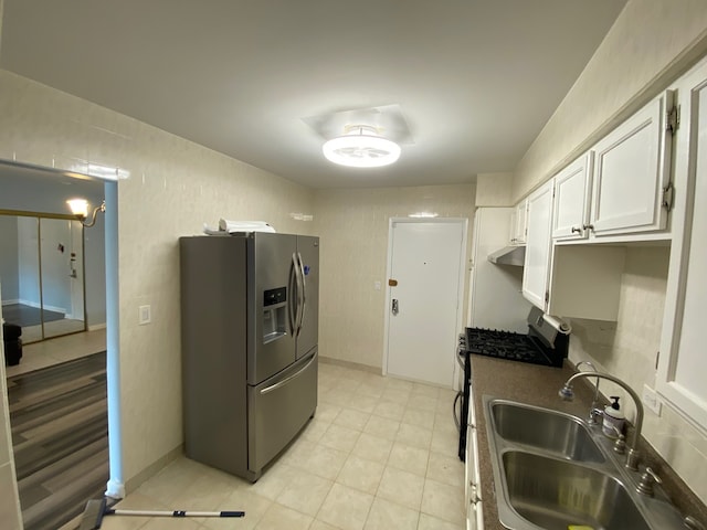 kitchen with appliances with stainless steel finishes, sink, and white cabinetry