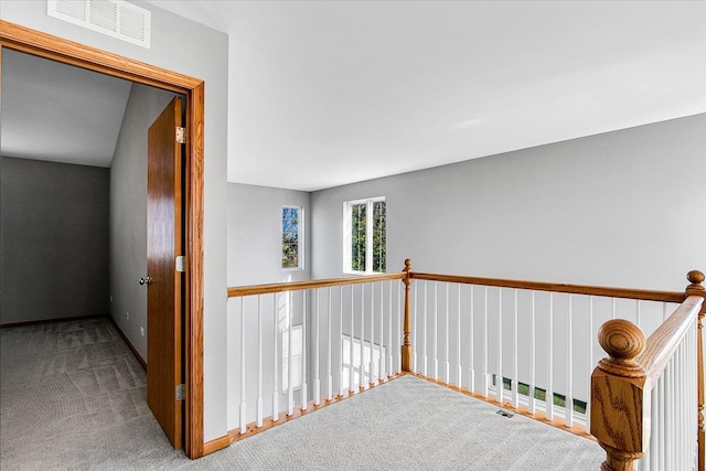 hallway with vaulted ceiling and carpet flooring