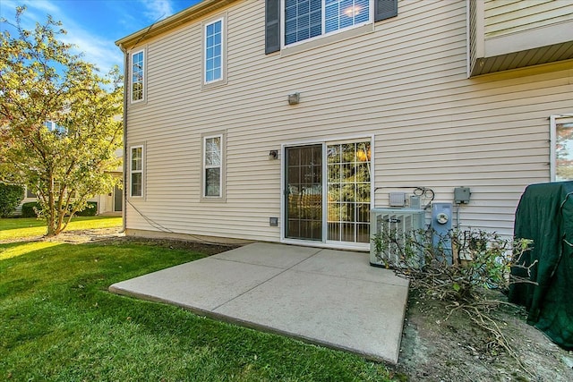 rear view of house featuring central AC unit, a patio area, and a lawn