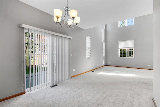 carpeted spare room with a notable chandelier