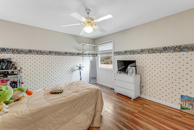 bedroom with baseboards, a ceiling fan, and wood finished floors