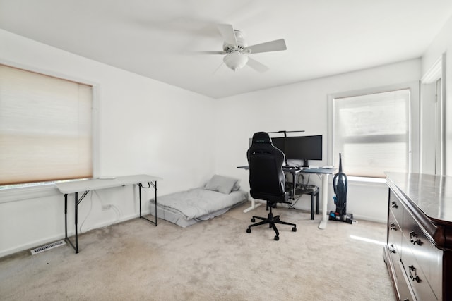 carpeted office space with ceiling fan