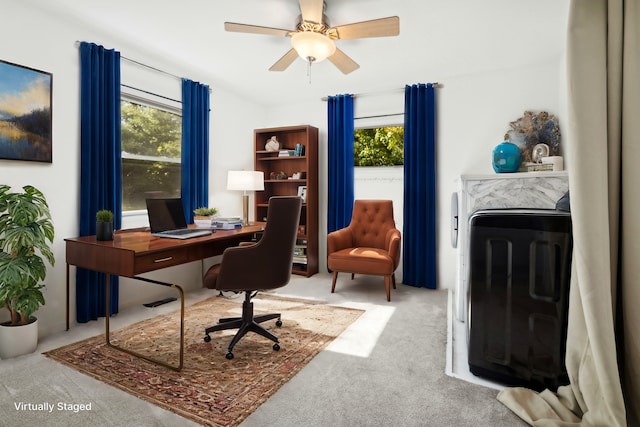 carpeted home office featuring ceiling fan