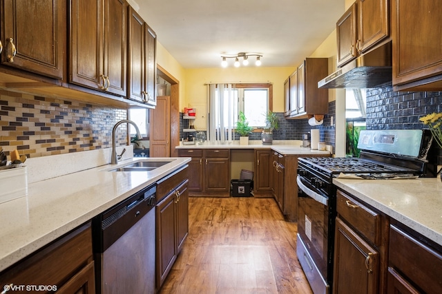 kitchen featuring tasteful backsplash, light hardwood / wood-style flooring, sink, stainless steel appliances, and light stone countertops