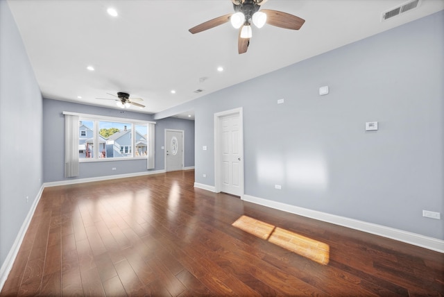 unfurnished living room featuring dark wood-type flooring and ceiling fan