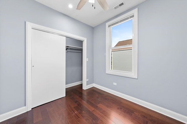 unfurnished bedroom with ceiling fan, a closet, and dark hardwood / wood-style floors