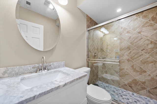 bathroom featuring vanity, walk in shower, and toilet